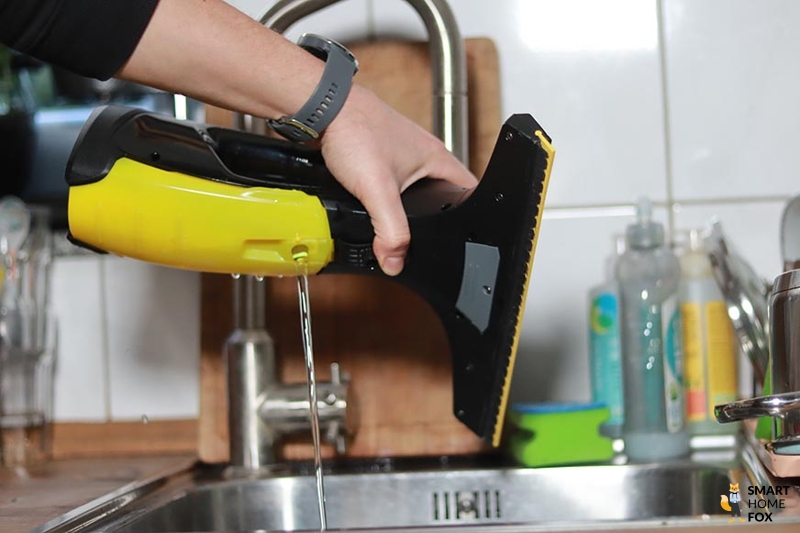 Man sieht wie der Tank eines Fenstersaugers entleert wird.